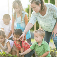 Teacher and children gardening together